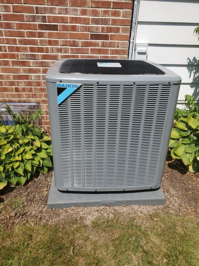 New Daikin air conditioner installed beside a brick wall