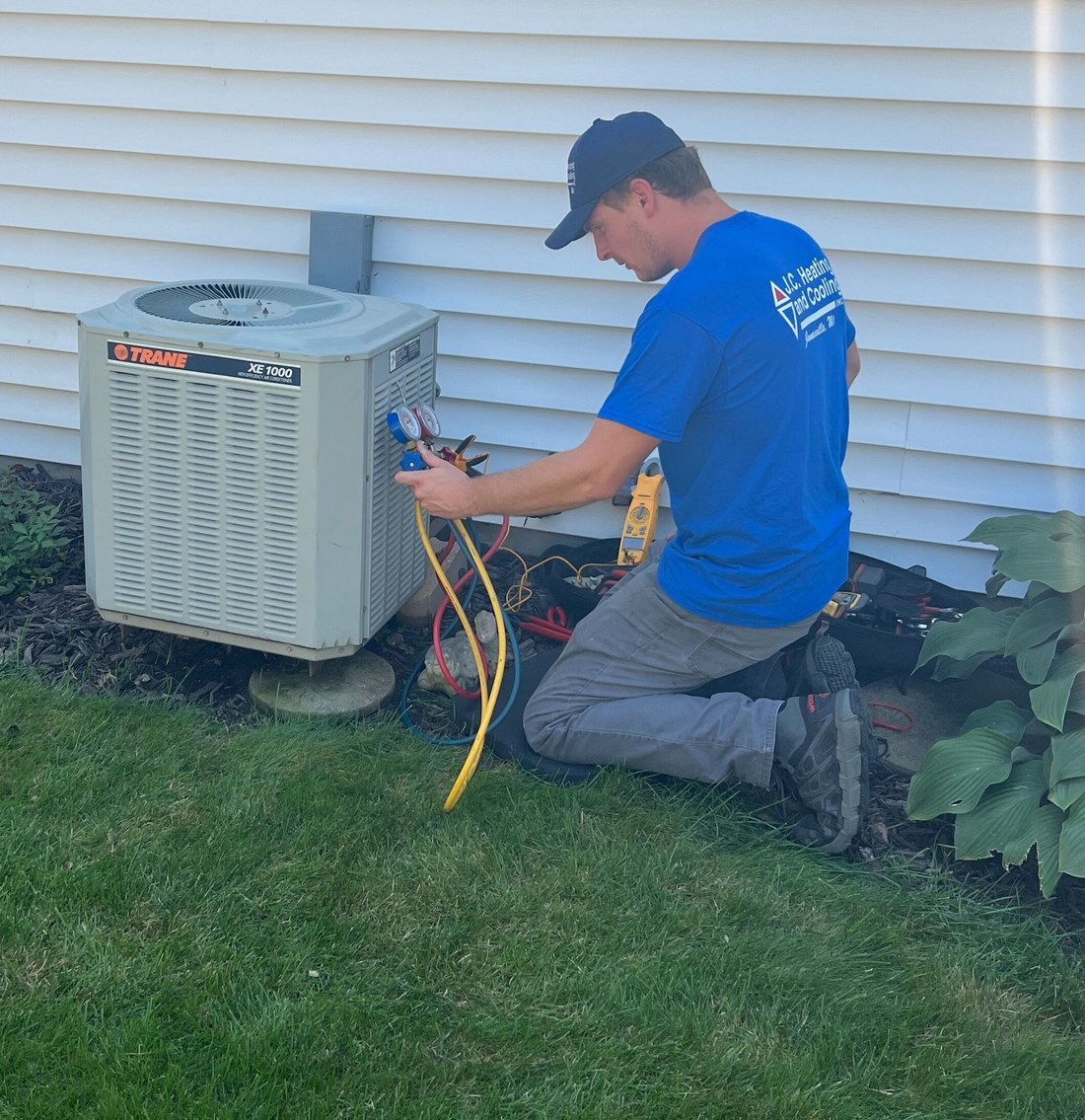 JC technician servicing an outdoor air conditioner