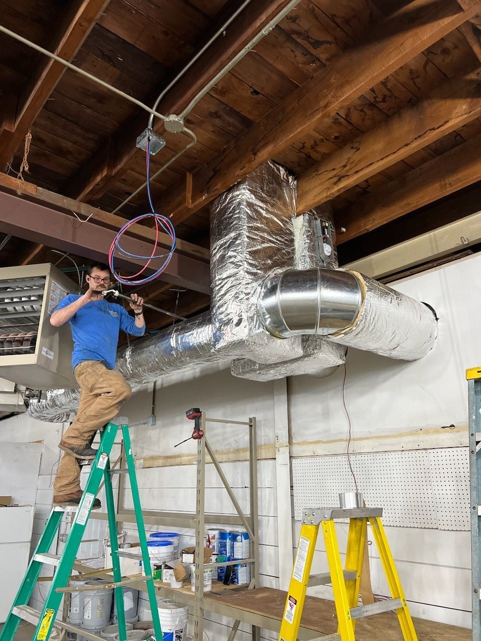 JC technician running ductwork on a commercial job